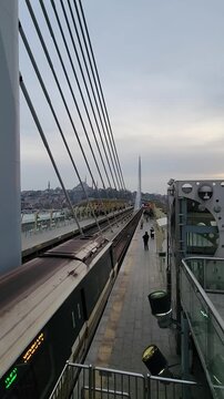 Beautiful aerial footage of the Halic tram passing through Istanbul with iconic mosque architecture in the background. Urban travel scenery with cultural city atmosphere.