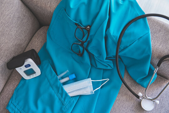 Teal nurse uniform with glasses, blood pressure monitor, face mask, and test tubes