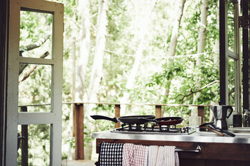 Naklejka premium Kitchen, house or cabin in woods for travel with accommodation interior, stove or cooking space. Balcony, home or cottage in forest with hob in room for hospitality, empty rental or lodge design