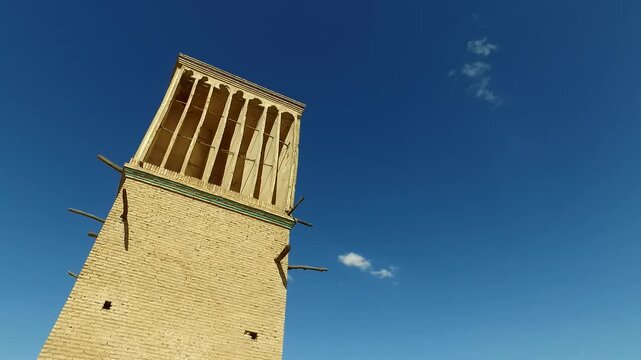  Isolated tall windcatcher against blue sky in Yazd, Iran, representing iconic Persian desert architecture, traditional, historic weather control, and ancient engineering brilliance. 