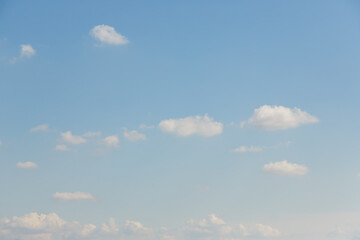 Wispy white clouds scattered across a vast pale blue sky on a bright day © Chmutphoto