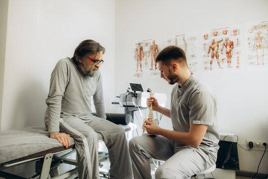 Doctor explaining spine model to patient during consultation