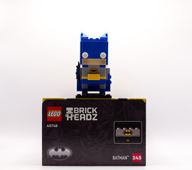 Naklejka premium Bologna - Italy - May 3, 2026: Blue batman lego brickheadz construction toy figure standing on top of its original packaging box over white background.