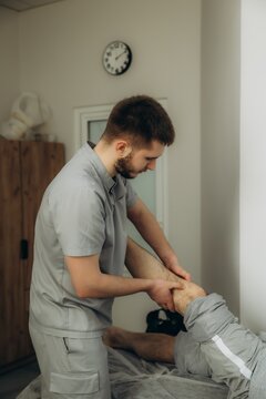 Professional physiotherapist performing knee rehabilitation therapy session