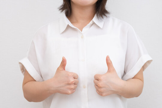 両手でグッドサインをする若い女性