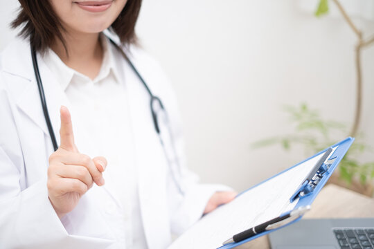 人差し指を立てる女性のお医者さん