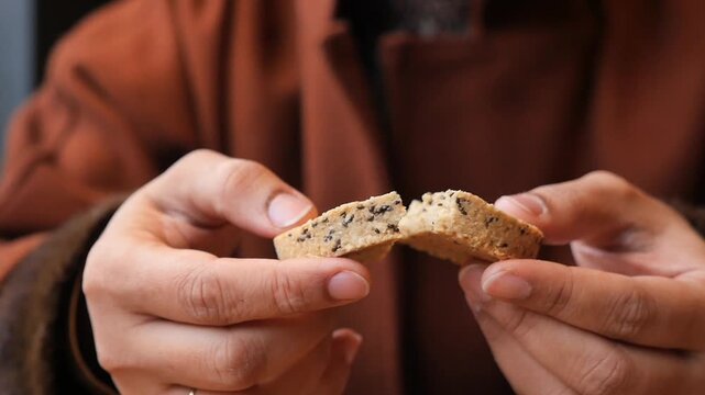 Person sharing cookie in cafe in city