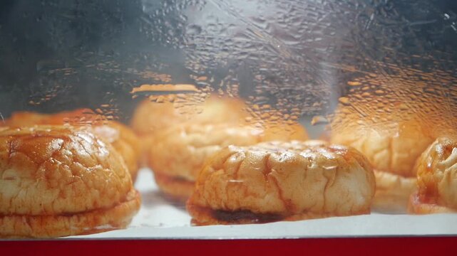 Fresh bread rolls are baking in an oven