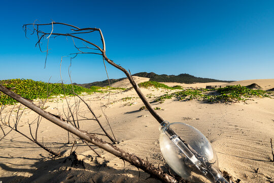 Discarded metal halide street lamp globe on sand dunes Gia Lai Vietnam