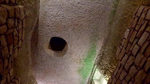 The interior of an ancient cave or underground room with textured stone walls. This unique view shows the mysterious atmosphere and structural details of a historical subterranean building. 