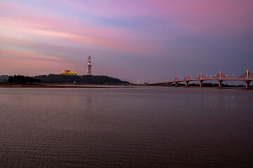 Fototapeta premium Sunset over Quang Ngai River with Buddhist statue silhouette Vietnam