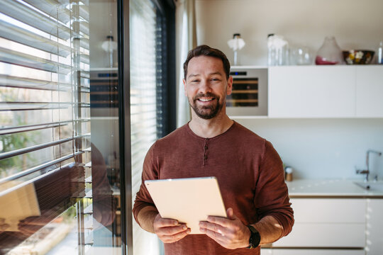 Man using smart home app to control electric window shades indoors.