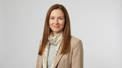 Obraz premium Smiling professional woman with beige blazer and scarf