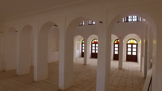  Interior hall with arches, columns and colorful glass windows creating rhythmic architectural perspective, revealing elegant historic design and cultural heritage atmosphere. 