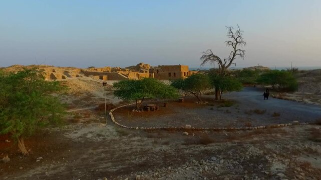  Ruins of an old mud brick village surrounded by dry plants and desert scenery. This stock footage captures the historical and archaeological beauty of a lost settlement in the arid plains. 