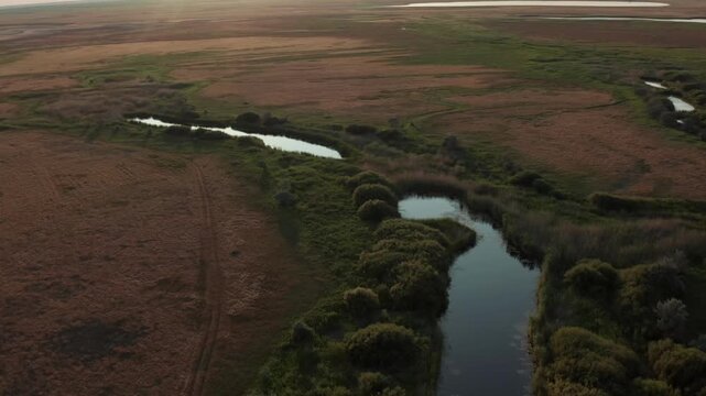 Aerial view of Ubagan river with wetlands, small lakes in steppe landscape of Kostanay region Kazakhstan, natural ecosystem with meandering water channels, untouched environment and vast open plains