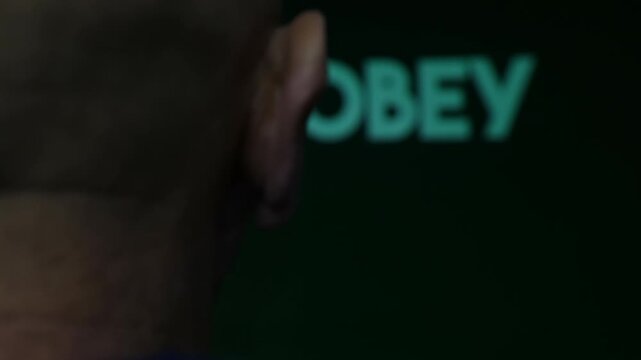 A man being brain washed to obey in an orwellian distopia authoritarian state