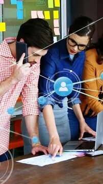 Vertical video: Design team pointing at docs, phone tap starting animated connections for review