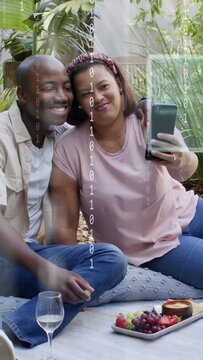 Vertical video: Couple on blanket woman showing AR tech handing phone to man reaching to share