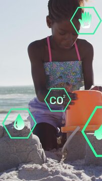 Vertical video: Kid molding sand in orange pail tipping  and  dumping firming castle teal hex icons 
