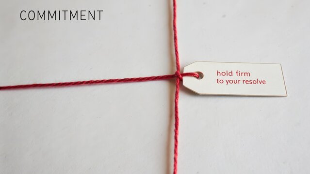Gift tag with red string on white background