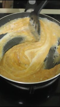 Chef Cooking Creamy Scrambled Eggs in a Non-Stick Frying Pan