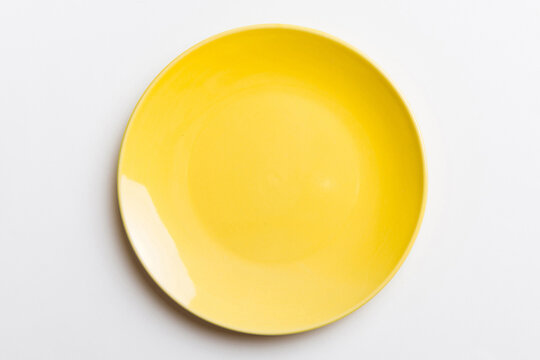 Top view of isolated of colored background empty round yellow plate for food. Empty dish with space for your design