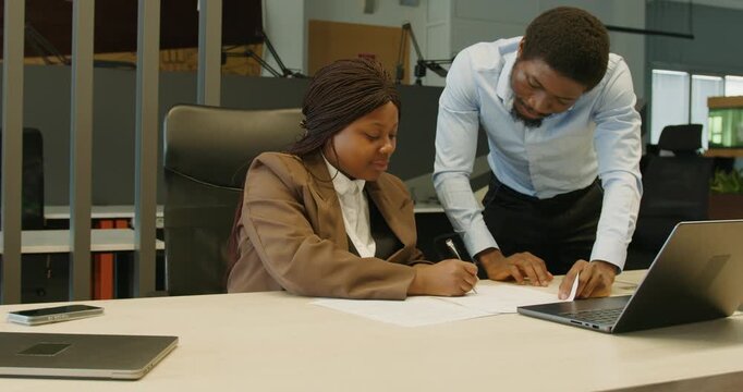 Colleagues happily evaluate project materials in professional environment