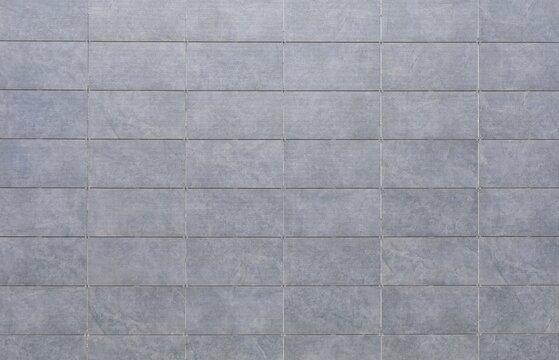 Light gray sintered stone tiles coating of a ventilated facade. Background and texture.