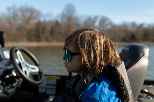 Profile of  boy wearing mirrored sunglasses and life jacket on boat