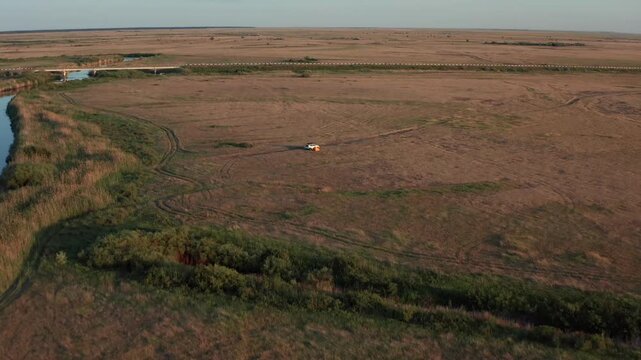 Aerial view of vast empty steppe with Ubagan river along horizon in Kostanay region Kazakhstan, minimal natural landscape with dry grass plains, remote wilderness and sense of isolation