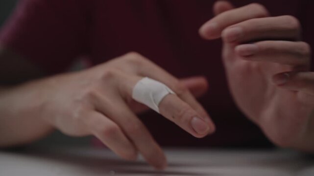 Injured person with bandaged middle finger showing offensive gesture of protest, expressing anger, frustration, defiance, and disrespect with rude hand signal, close-up. Shooting in slow motion.