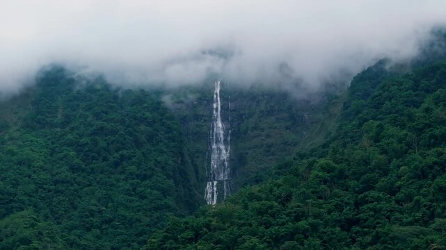 Aerial view misty foggy mountain landscape with clouds and waterfall