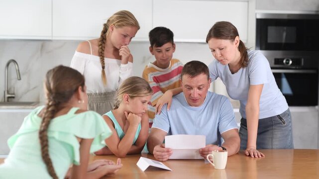 Big family meeting at home kitchen reading and discussing recived upset letter