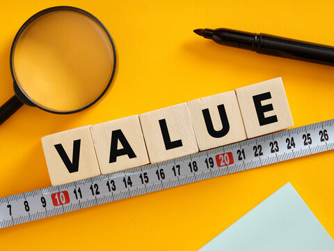 Measuring value with magnifying glass, marker and measuring tape on yellow background