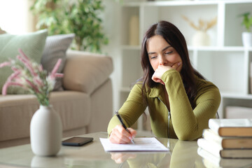 Pensive young woman filling out form on a coffee table