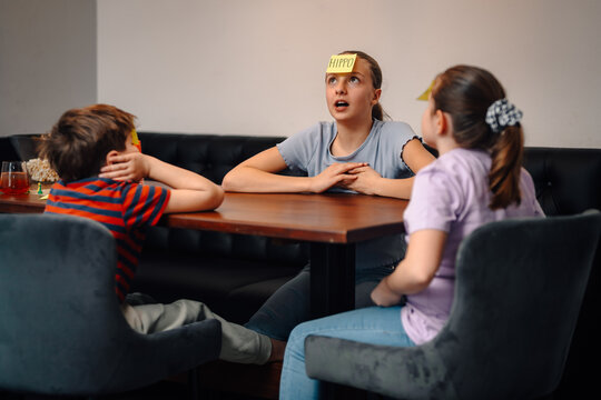 Children playing guessing game having fun together at home