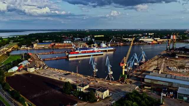 Wide view of an industrial port with blue cranes and ship docks