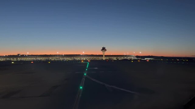 An immersive cockpit view taxiing to Madrid Arirport runway for takeoff just before sunrise, with control tower and Terminal 4S at the background