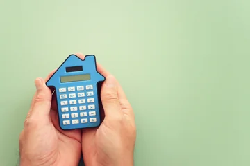 Calculator in the shape of a house. Idea of expenses and real estate © tomertu