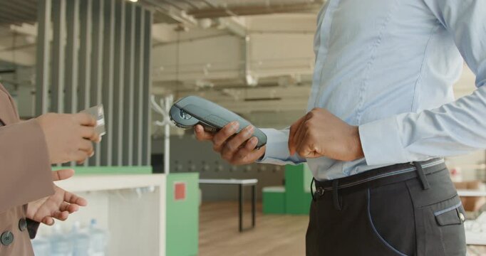 Professional staff member presents compact payment device at front desk