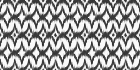 Fototapeta na wymiar Ikat ethnic seamless pattern with abstract print. Vector ornamental background with rug texture for textile decor. Retro monochrome rhombus decoration with dye effect