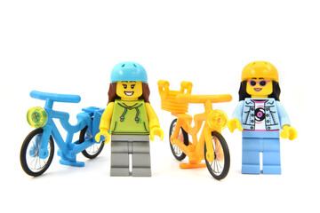 Naklejka premium Editorial illustrative image of lego minifigures of girls bikers with yellow and blue bikes isolated on white.