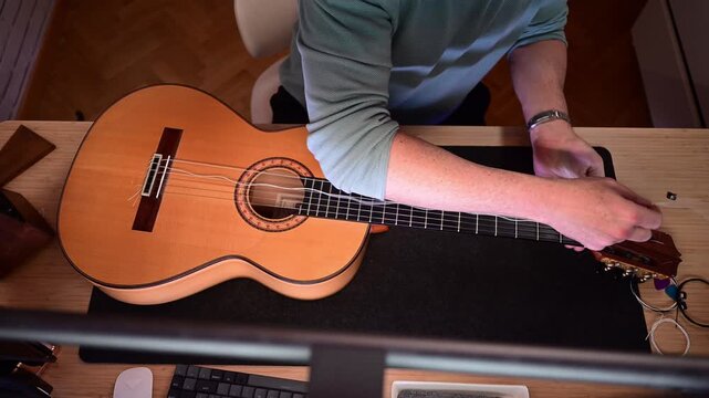 Luthier carefully changing strings on a classical guitar