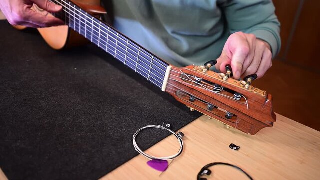 Luthier carefully changing the strings on a classical guitar
