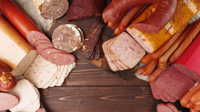 Variety of cured meats arranged on a wooden surface in a dining setting