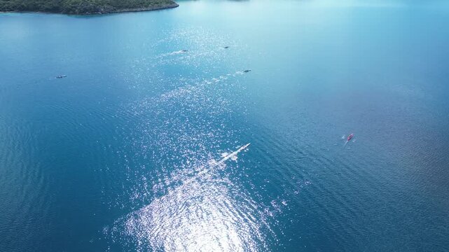 Aerial View of Rowing Race Competition in Turquoise Sea Near Coastal Hills. High quality 4k footage