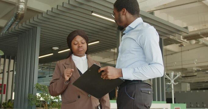 Professional woman analyzes tablet during tense meeting