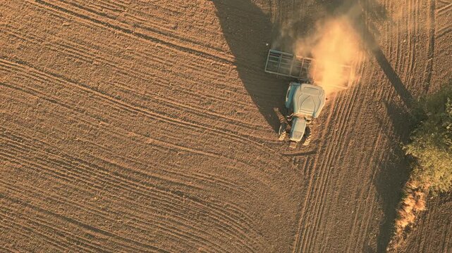 Aerial View of Tractor Plowing Brown Soil in Agricultural Field, Preparing Land for Planting. High quality 4k footage