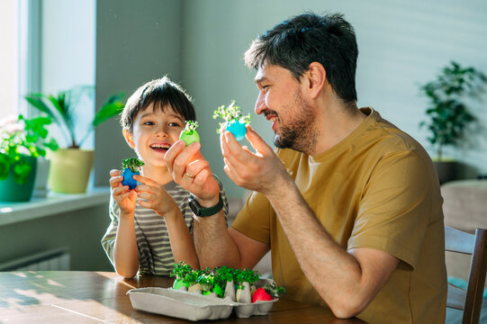 Family smiling indoors holding Easter egg with growing microgreen